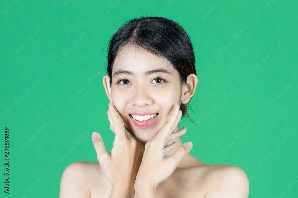 Beauty young Asian woman touching her face over green isolated background. Healthy skin care concept. Beauty young Asian woman touching her face over green isolated background. Healthy skin care concept.