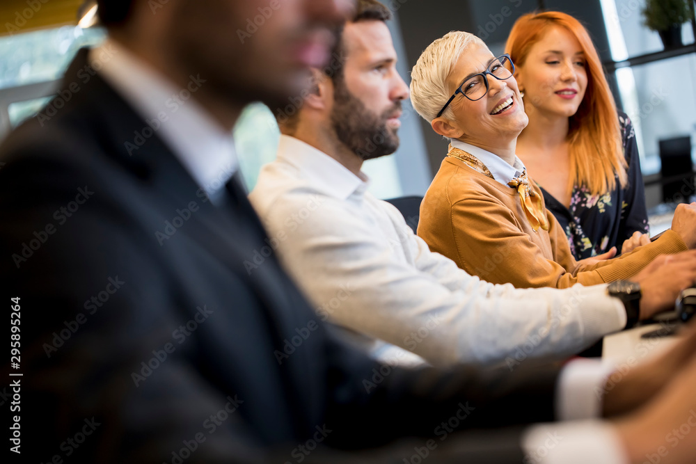 Businessman executive in group meeting with other businessmen and businesswomen in modern office with computer Businessman executive in group meeting with other businessmen and businesswomen in modern office with computer