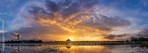 Panorama image. sunset on dark background.Vivid orange cloud sky.