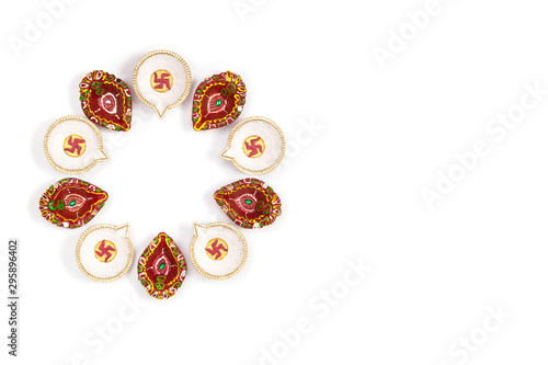 Happy Diwali - Clay Diya lamps lit during Dipavali, Hindu festival of lights celebration. Colorful traditional oil lamp diya on white background. Copy space for text.