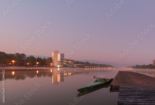 Purple dawn and a view of the Rowing canal in Plovdiv - European Capital of Culture 2019. A wooden pier and a boat near it on the mirror surface of the water. Nature in the city - concept, background.