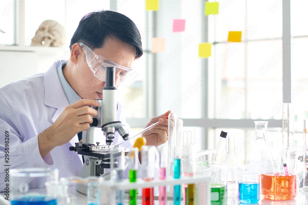 Asian male scientist look through the microscope in the laboratory. Asian male scientist look through the microscope in the laboratory.