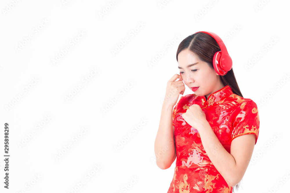 The image of an Asian girl in a traditional Chinese dress, Cheongsam, black hair, so sad, wearing headphones to listen to music.