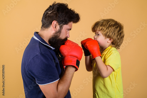 Boy boxing training punch exercise concept. Father and son during boxing training. Cute little boy training with boxing coach. Little boy boxing with trainer. Boy boxer practicing punches with coach. © Svitlana