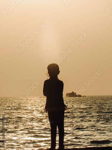 silhouette of a girl on the beach at sunset
