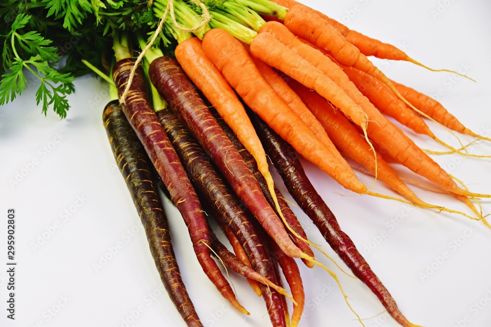 Bunch of fresh red and orange carrots on the white background Bunch of fresh red and orange carrots on the white background