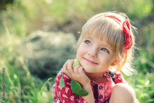 Cute Little girl with a Apple in Her Hand Outdoors.
