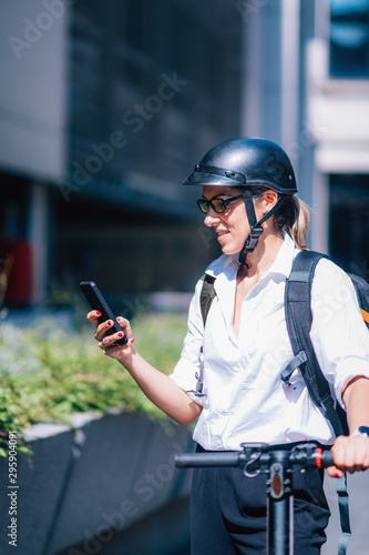 Businesswoman with Smart Phone and Electric Scooter in The City.