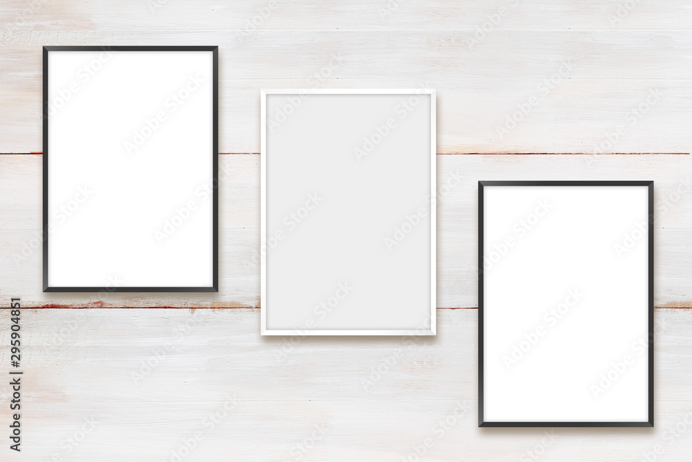 White and black photo frames on a wooden wall