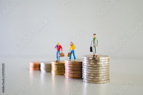 Miniature people, group of business team standing on stack coins using as business and financial concept