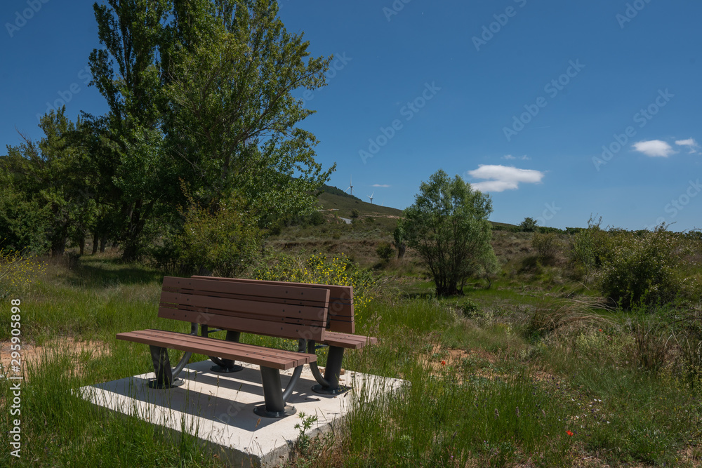 Closeup view of a wood bench isolated on the nature during a summer day with a big blue sky - Image Closeup view of a wood bench isolated on the nature during a summer day with a big blue sky - Image