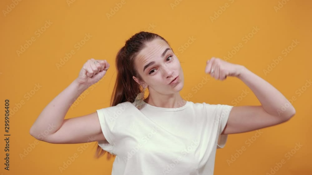 Clip of a nice girl dancing around. She is relaxed that's why doing some moves by waving her hands up behind her is orange background as she is wearing white t shirt. Clip of a nice girl dancing around. She is relaxed that's why doing some moves by waving her hands up behind her is orange background as she is wearing white t shirt.
