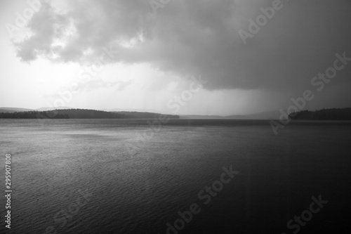 Dark, Foreboding Storm Clouds Over A Gloomy Gray Lake Landscape