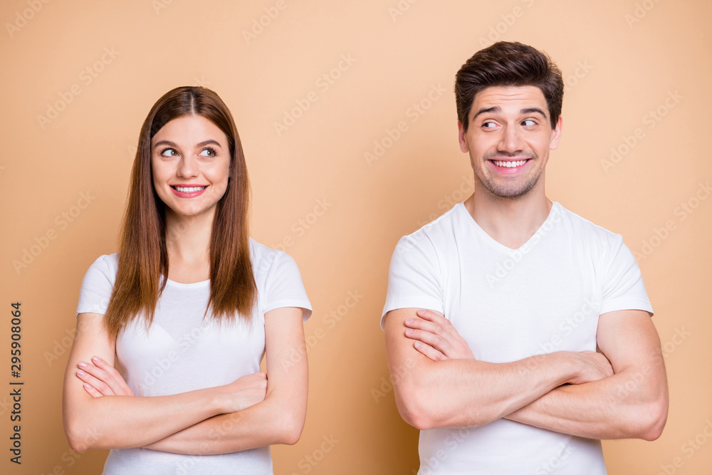 Close-up portrait of his he her she nice attractive cheerful cheery discontent shy couple wearing white t-shirt folded arms awkward meet isolated over beige pastel color background Close-up portrait of his he her she nice attractive cheerful cheery discontent shy couple wearing white t-shirt folded arms awkward meet isolated over beige pastel color background