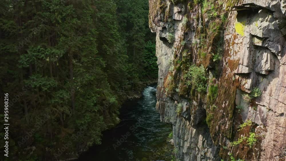 Stunning Drone shot flying close, above the cliff face and and the stream of the Capilano River in Vancouver, British Columbia, Canada Stunning Drone shot flying close, above the cliff face and and the stream of the Capilano River in Vancouver, British Columbia, Canada