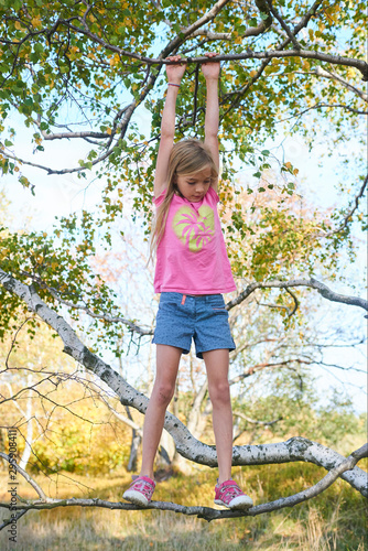 Child brave cute girl climbing on tree