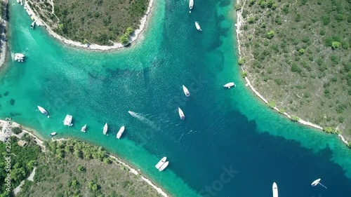 Aerial view of white luxurious yachts embarked in bay with turquoise, crystal clear water during summer season. Sailing experience during yacht week.