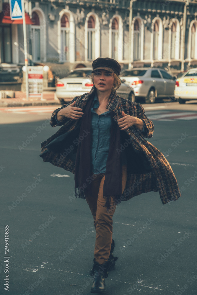 Elder adult caucasian woman on a walk in european street. Autumn retro outfit. Vintage styled and toned image with grain as film imitation Elder adult caucasian woman on a walk in european street. Autumn retro outfit. Vintage styled and toned image with grain as film imitation