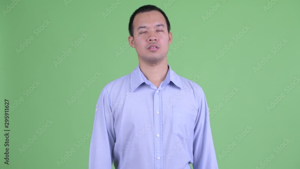 Happy Asian businessman relaxing with eyes closed Happy Asian businessman relaxing with eyes closed