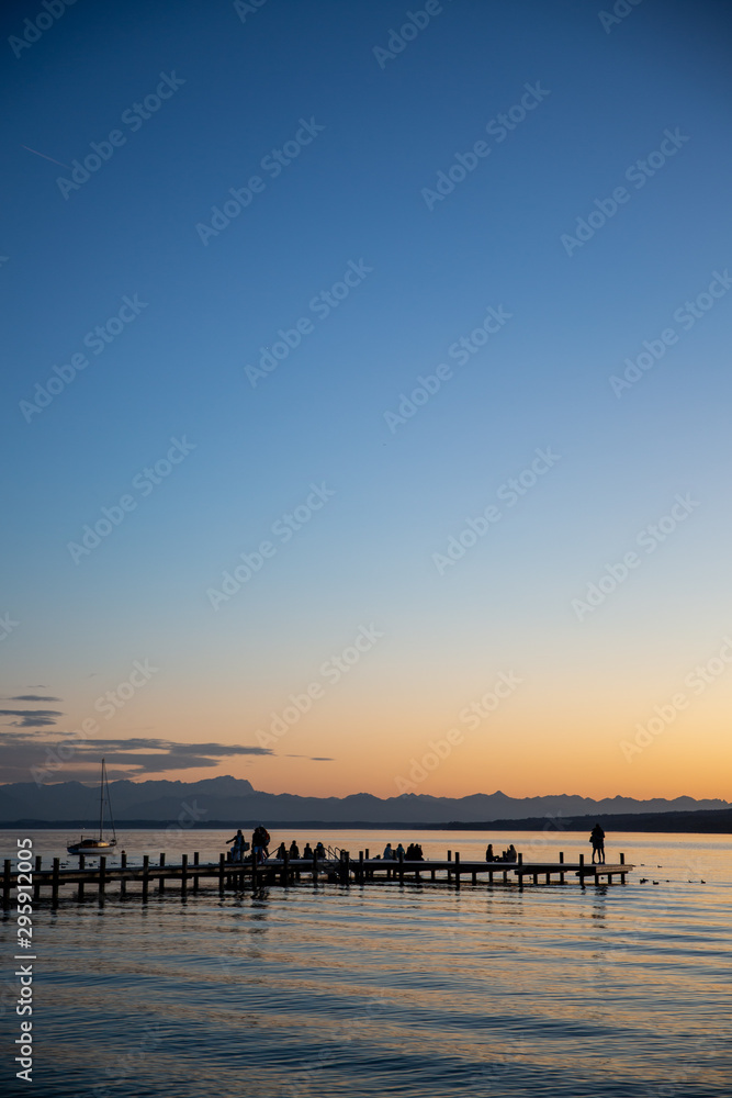 Steg in Percha am Starnberger See am Abend mit Bergblick