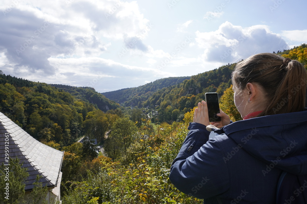 girl photographs forest mountains, capture the moment, autumn landscape, trees with colored foliage. change of seasons, warm and Sunny autumn