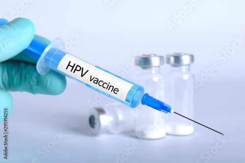  Vaccination healthcare concept. Hands of doctor or nurse in medical gloves with medical syringe ready for injection a shot HPV vaccine. close up, selective focus - Image