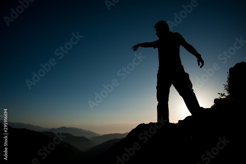 silhouette of man on top of mountain © omer_kuru