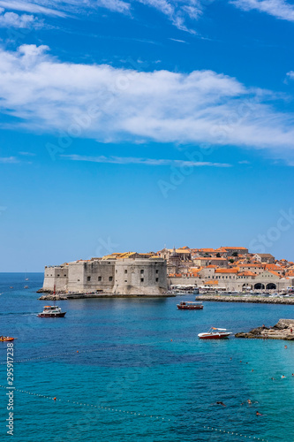 Fototapeta Naklejka Na Ścianę i Meble -  Old city walls in historic Dubrovnik city, Dalmatia, Croatia, emerald Adriatic Sea and blue summer sky with clouds, popular touristic destination, nice background image