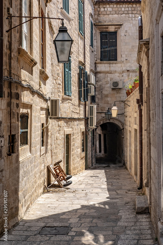 Narrow stone street with stone houses, facade and lanterns in Dubrovnik city, Dalmatia, Croatia, popular touristic destination