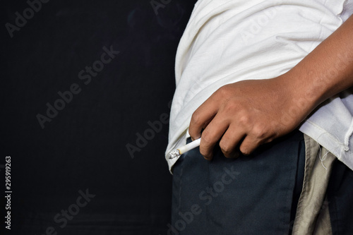 Hand of asian man holding cigarettes with black background. Smoking cigarettes concept