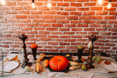 Table setting for Thanksgiving day. Autumn table with pumpkins and candles. fall home decoration for festive dinner 