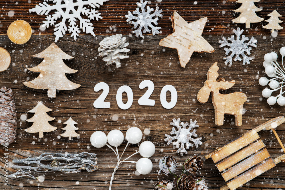 White Letters Building The Word 2020. Wooden Christmas Decoration Like Tree, Sled And Star. Brown Wooden Background With Snowflakes White Letters Building The Word 2020. Wooden Christmas Decoration Like Tree, Sled And Star. Brown Wooden Background With Snowflakes