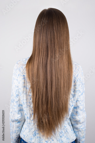 Vertical close up back behind rear view photo of woman demonstrating showing her long but problematic hair isolated grey background