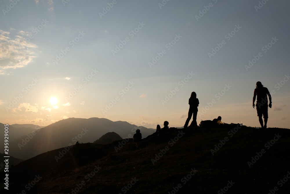 Black silhouette of tourists waiting for sunset on peak Lomis Mta in Borjomi-Kharagauli National Park, Georgia. 