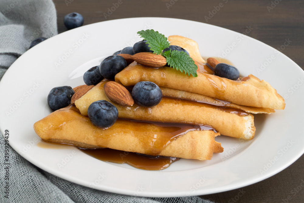 pancakes with syrup nuts and blueberries. on a white plate pancakes with syrup nuts and blueberries. on a white plate