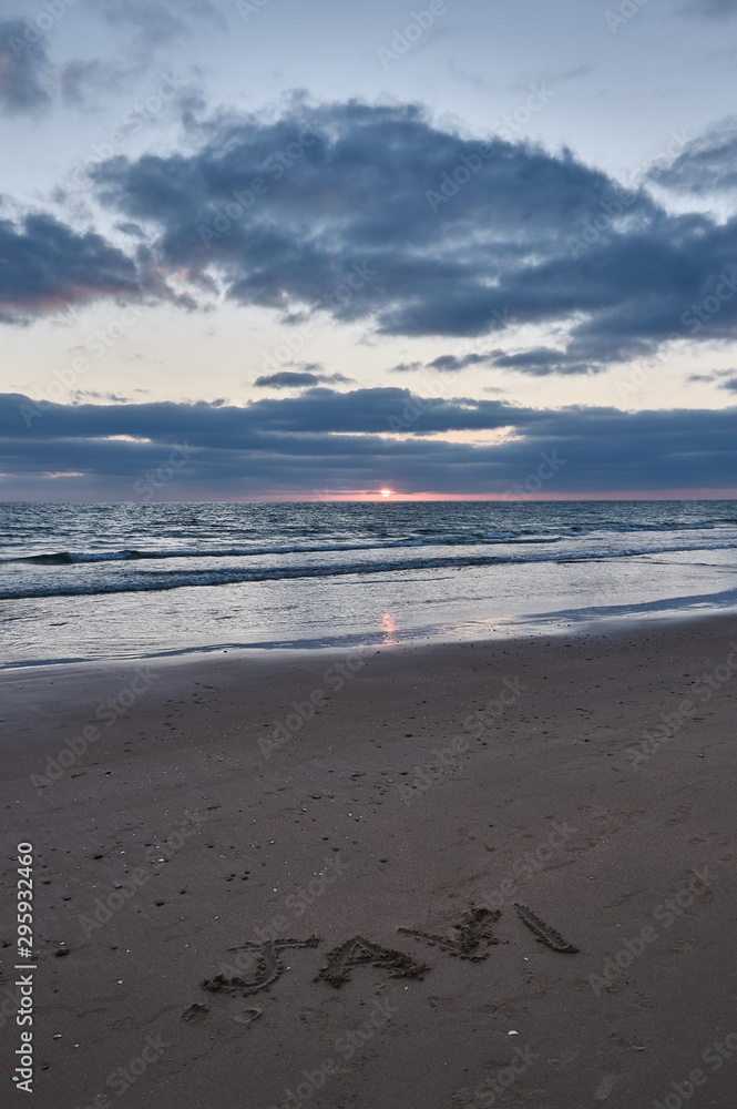 El nobre de JAVI escrito en la arena en la puesta de sol, en la playa de El Palmar, perteneciente a Vejer de la Frontera, en la provincia de Cádiz. Andalucía. España