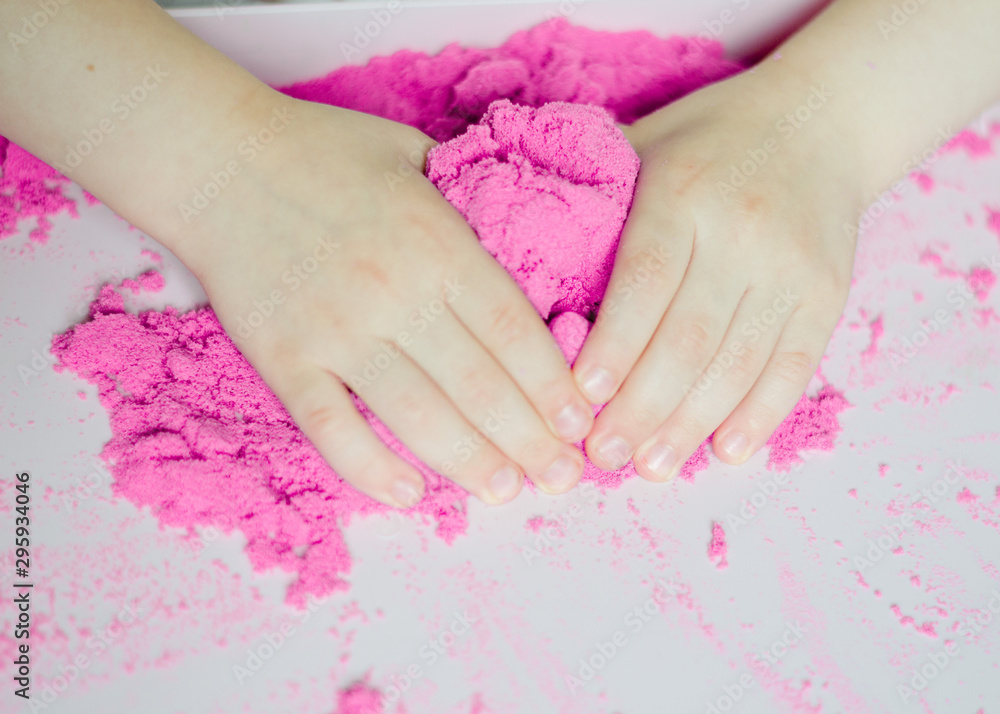 kid play kinetic sand. Pink sand. Magic sand. Close up kid play kinetic sand. Pink sand. Magic sand. Close up