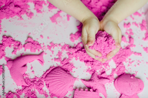 kid play kinetic sand. Pink sand. Magic sand. Close up © Julia