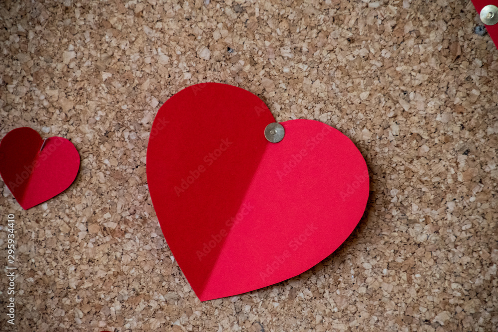 colorful cut out paper hearts on a brown cork background, colorful cut out paper hearts on a brown cork background,