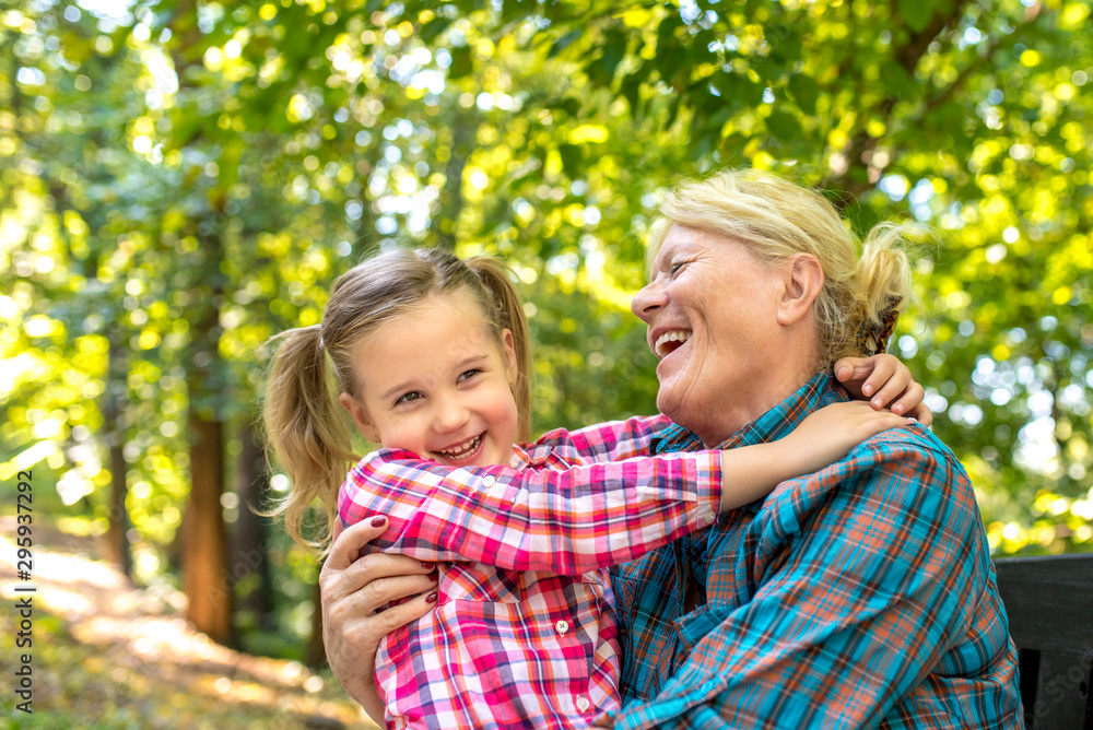 Grandmother and granddaughter hugging and enjoying in park Grandmother and granddaughter hugging and enjoying in park