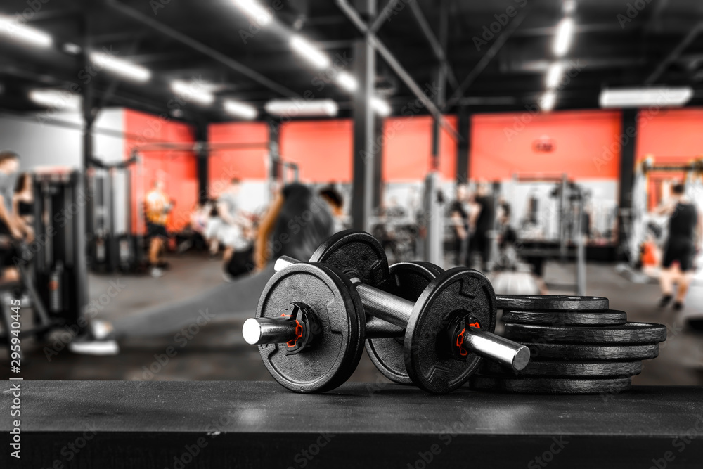 Dumbbell, barbell and workout in the gym.  Copy space with blurred gym background.