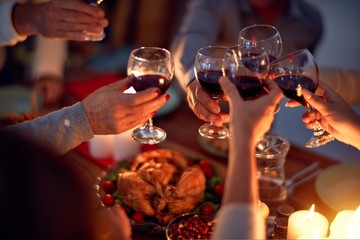 Family and friends dining at home celebrating christmas eve with traditional food and decoration, all sitting on the table together