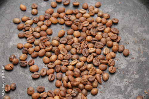 Green coffee beans roasting on the black pan