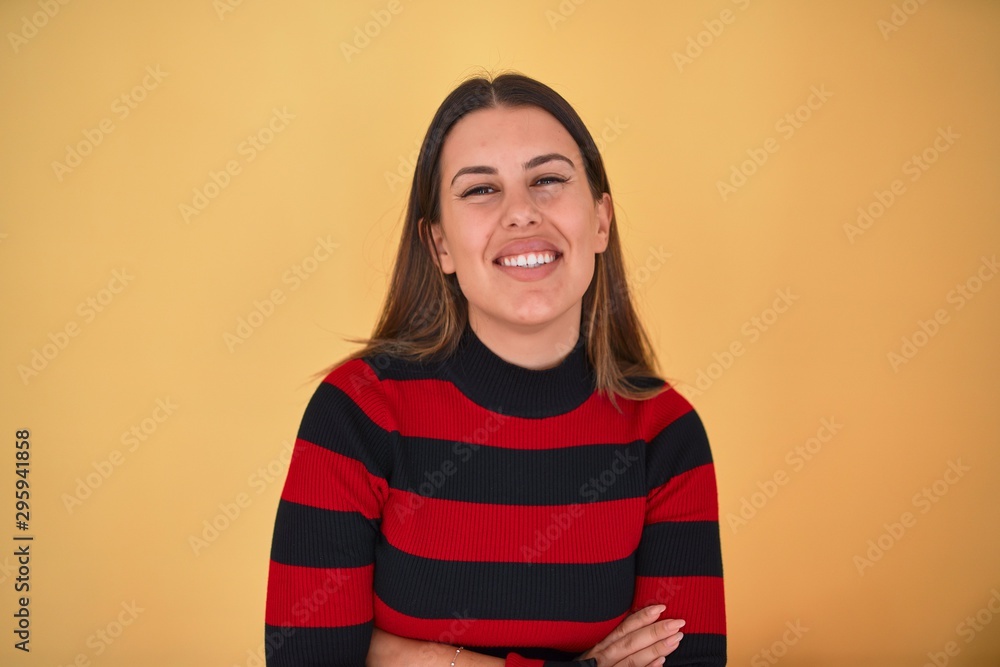 Young beautiful woman smiling happy wearing a sweater over isolated yellow background Young beautiful woman smiling happy wearing a sweater over isolated yellow background