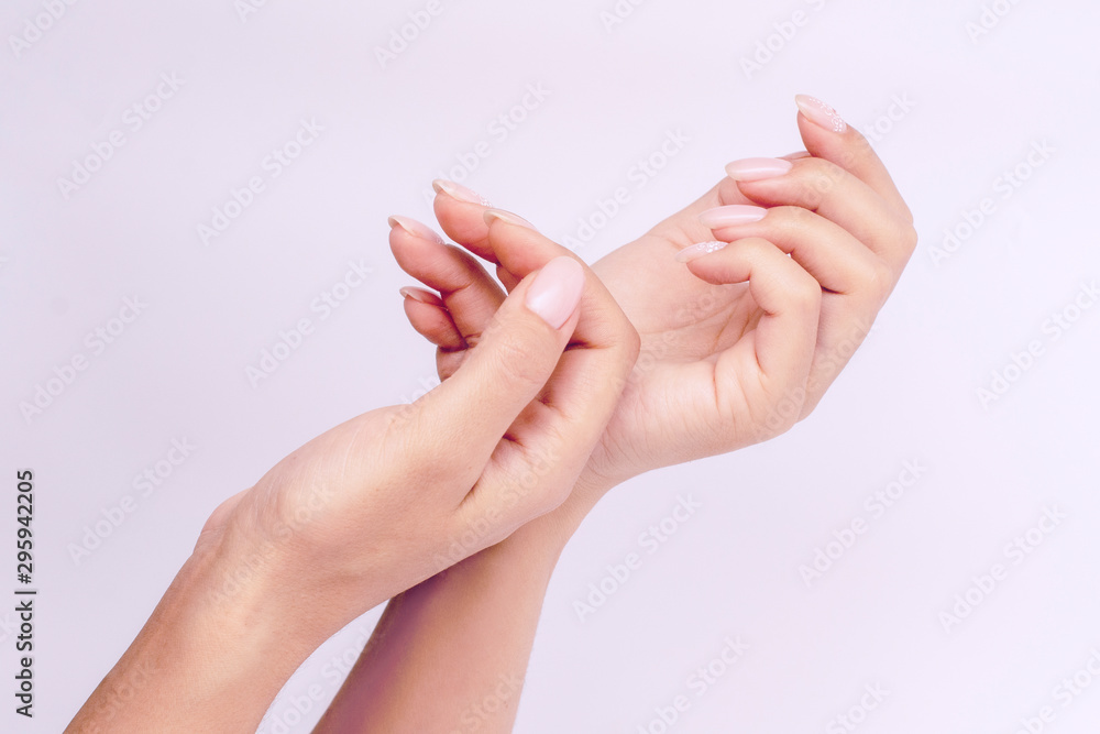 Well-groomed delicate female hands with pink manicure. minimalism.