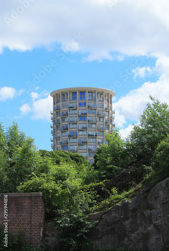 Modern round building with balconies against a cloudy sky.