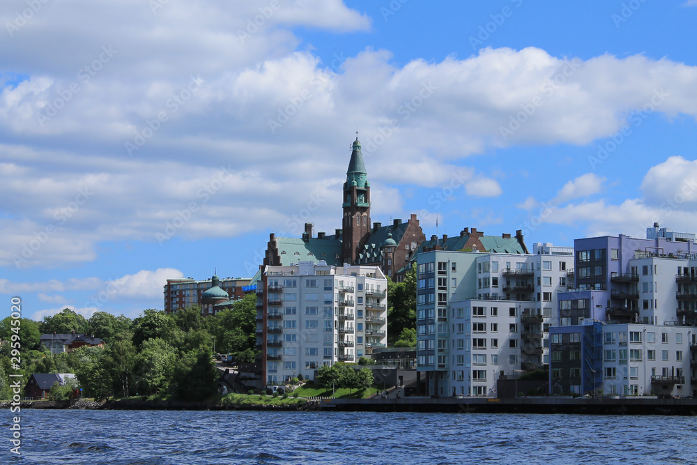 Modern houses in a residential area of Stockholm. White-gray buildings, in the center of an old building with a tower.
