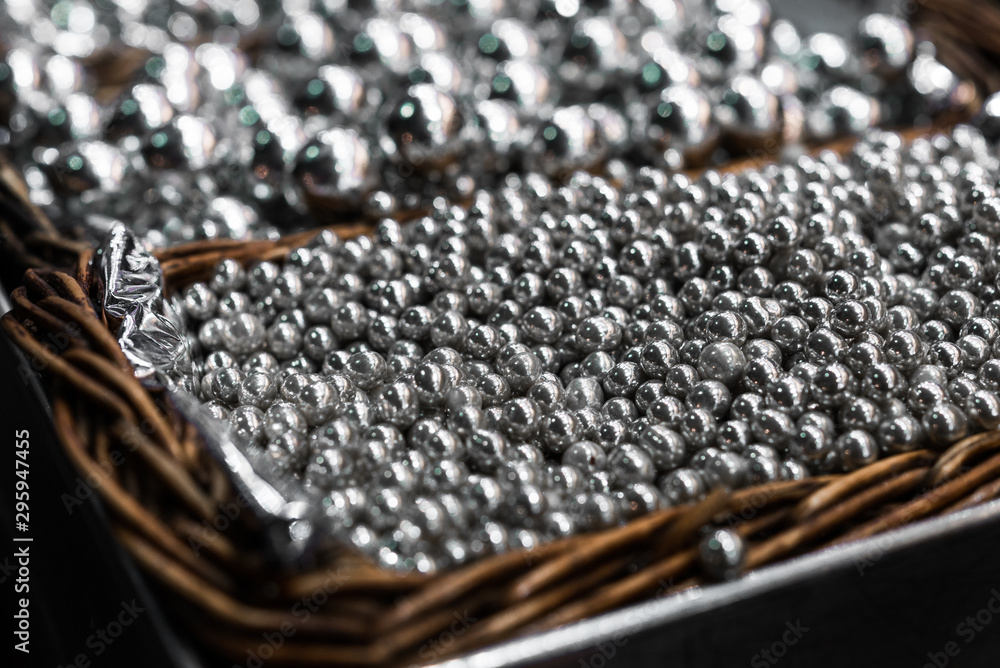 Silver sprinkle sugar candy for cake decoration in a wooden basket Silver sprinkle sugar candy for cake decoration in a wooden basket