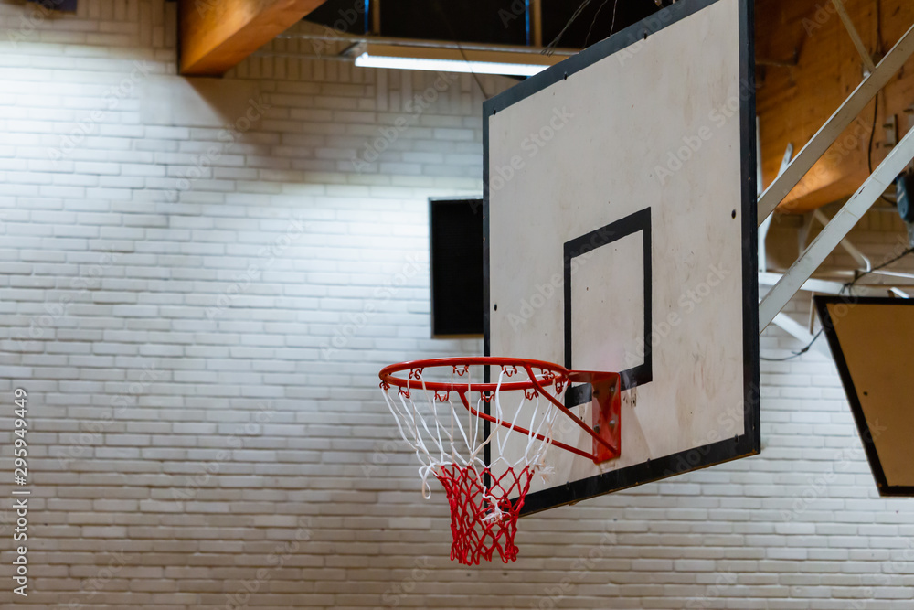 Used basketball backboard, hoop, net inside of basketball court, Right side view