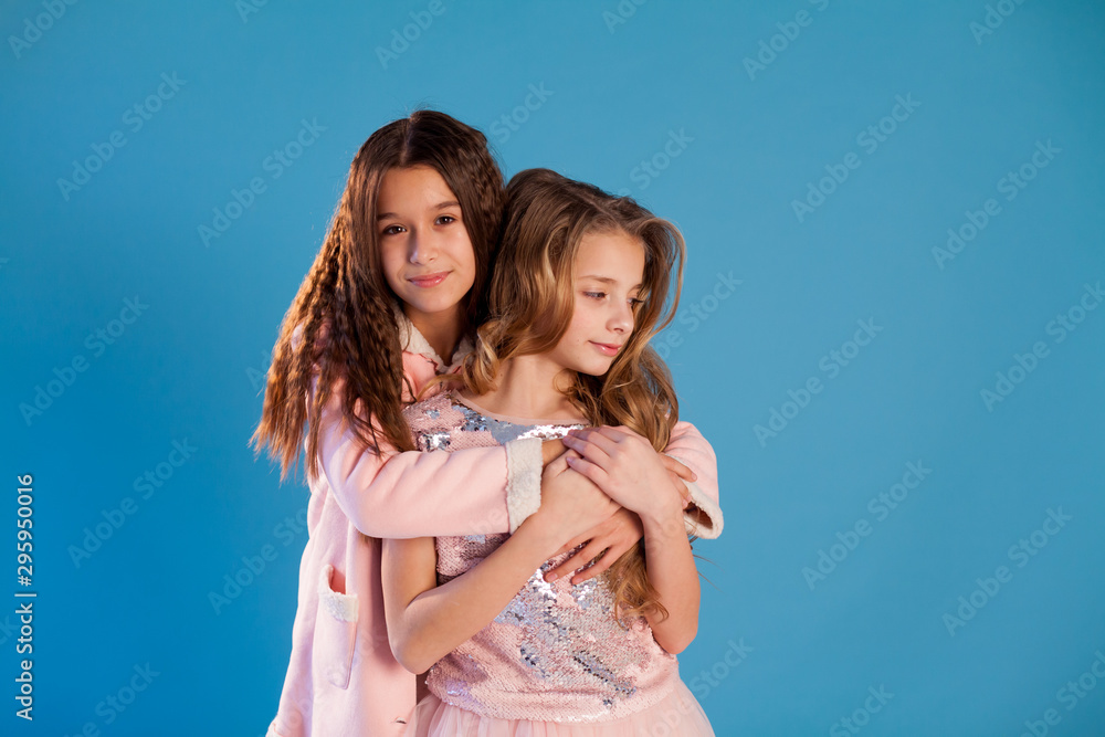 Fototapeta premium Two fashionable girls school girlfriends in white pink dresses
